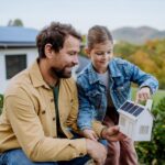 Wärmepumpe Niederösterreich - Familie vor Haus mit Photovoltaikanlage"