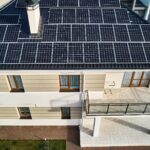 Modern house with solar panel electric system on rooftop.